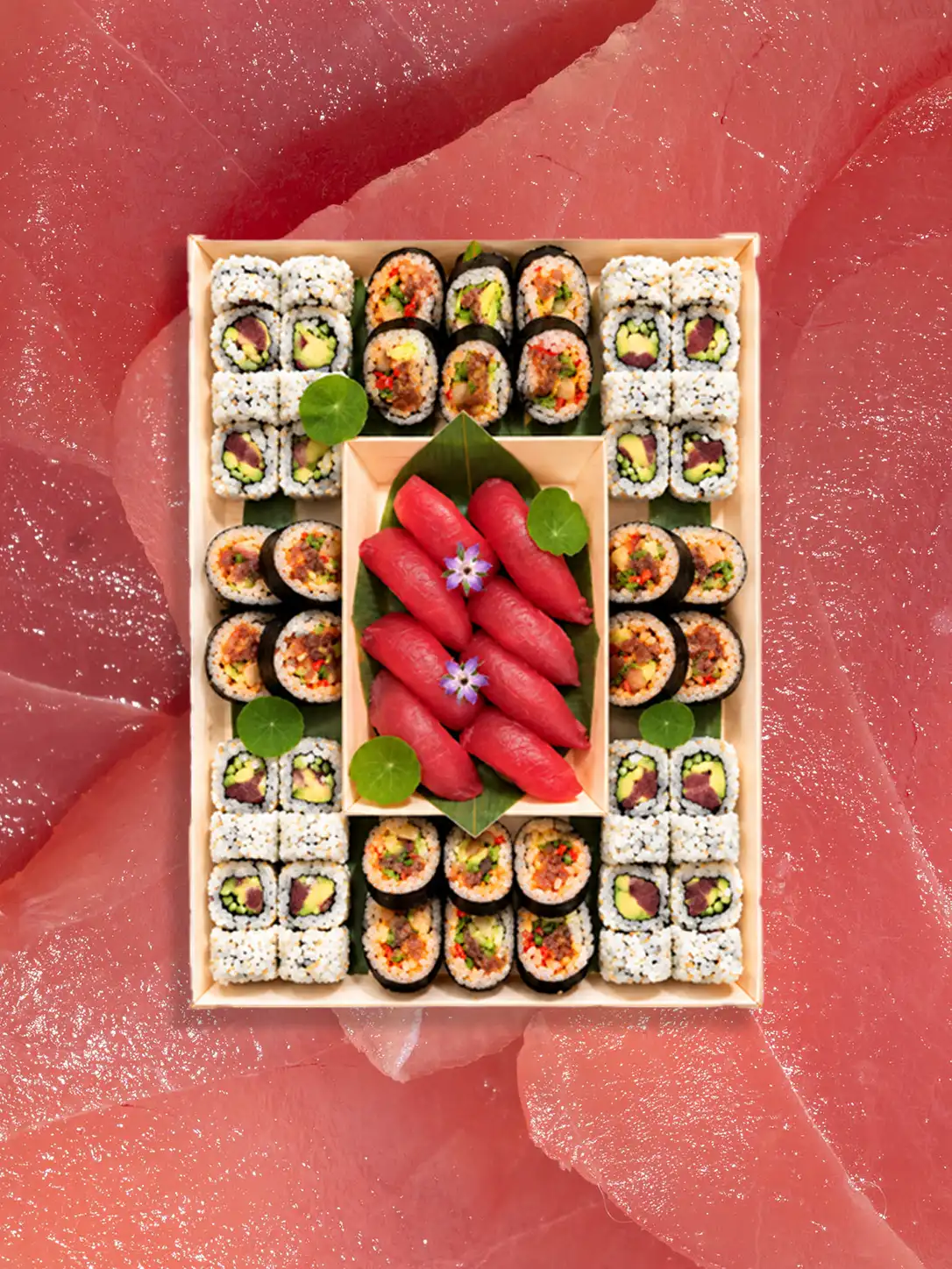 Tuna Lovers catering tray of sushi rolls and tuna nigiri on a fresh tuna background