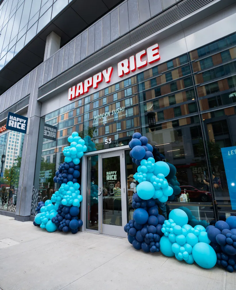Happy Rice storefront at 53 Boston Wharf Road in Boston’s Seaport, decorated with blue balloons