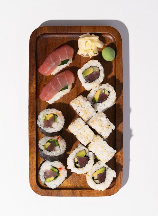 Power Up Box with tuna avocado rolls, spicy tuna and tuna nigiri on a wooden tray